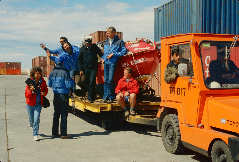 Arrival of the Sea Tomato. On the truck (front to back): Bud Keene, Mark Eichenberger (standing), a Port Official, Jon Turk, and Ned Gillette (waving).